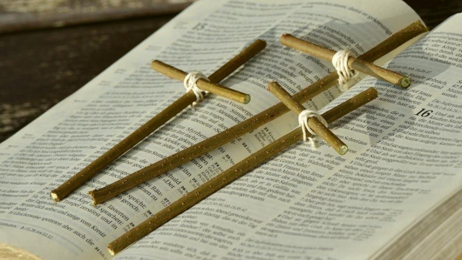 Bibel mit drei Kreuzen aus Stöcken